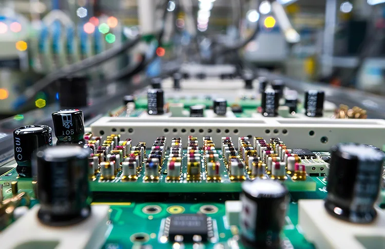 Populated printed circuit boards moving along an electronics assembly line